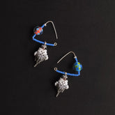 Pair of parrot earrings with blue beads and star-shaped charms on a black background