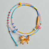 Colorful beaded necklace with a cat-shaped charm on a light gray background