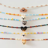 Colorful beaded necklaces with dog charms on a white background