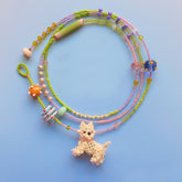 Colorful beaded necklace with a Westie dog charm on a blue background
