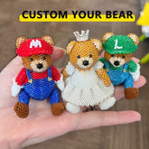 Three customizable teddy bears with different outfits held in a hand.
