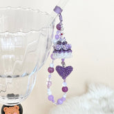 Decorative purple beaded cake ohine charm on a white background