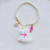 Pearl bag charm with a cat charm on a light gray background