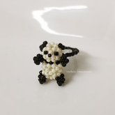 Panda-shaped beaded ring on a white background