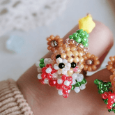 Close-up of a beaded ring shaped like a bear held on a blurred background