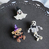 Three beaded Halloween characters rings on a dark surface