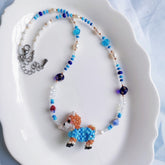 Beaded necklace with a Shiba Inu dog figure on a white dish