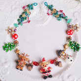 Colorful beaded necklace with reindeer and Christmas tree decorations on a white lace background