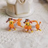 Two beaded dog rings on a textured white surface