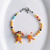 Colorful beaded sausage dog bracelet with a dog-shaped charm on a white background - verhalo custom jewelry