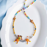 Colorful beaded necklace with dog charms on a white plate