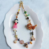 Colorful beaded bag charm with a little girl and her dachshund dog on a white plate - Verhalo custom jewelry