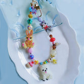 Handmade colorful beaded bag charm with a cat , a dog and a bunny on a white plate 丨Verhalo Custom Jewelry