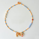 Colorful beaded necklace with a cat pendant on a light gray background