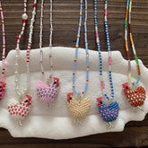 Beaded necklaces with chicken pendants on a white surface. - verhalo handmade jewelry