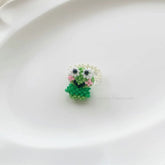 Small green beaded frog on a white plate