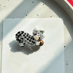 Beaded tabby cat charm on a white surface with a speckled background - verhalo handmade jewelry
