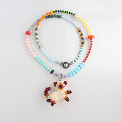 Colorful beaded necklace with a cat pendant on a light gray background