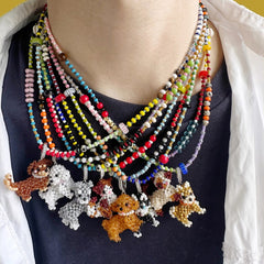 Colorful beaded necklace with dog charms on a person wearing a black top.
