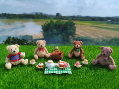 Knitted teddy bears having a picnic on grass with a scenic background