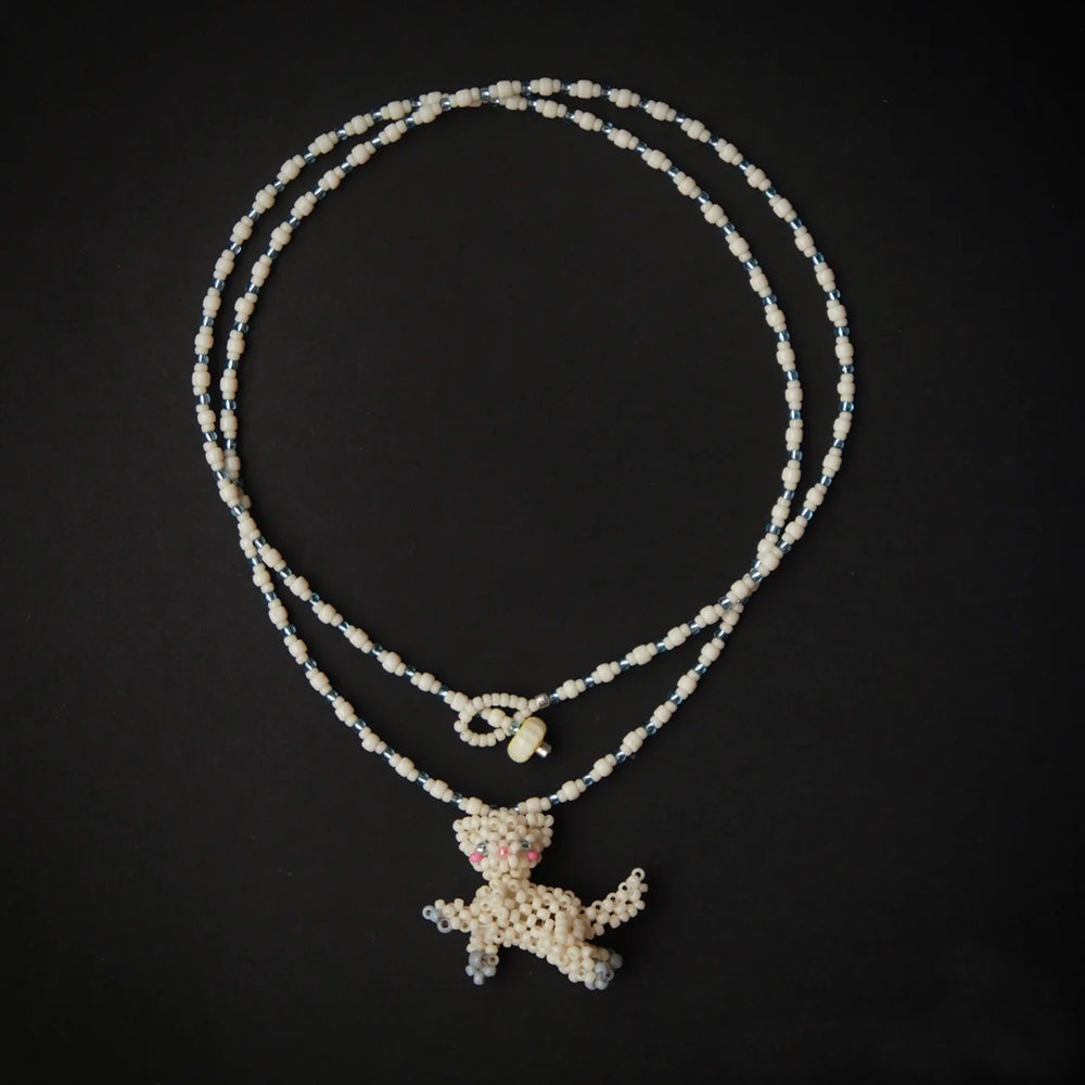 Necklace with a white cat pendant on a black background