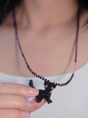 Necklace with a black cat pendant held by a person against a neutral background