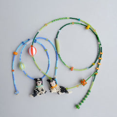 Colorful beaded necklaces with dog pedant on a light gray background