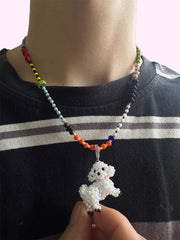 Bichon Necklace with a white beaded pendant held by a person wearing a black shirt with stripes. - verhalojewelry