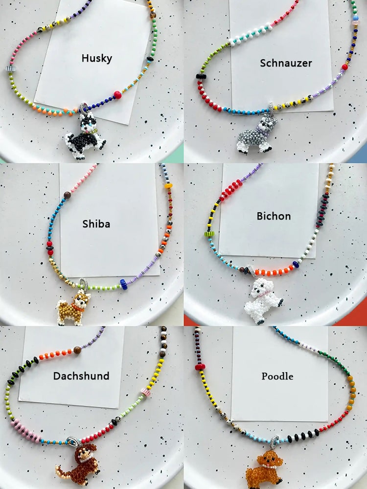 Set of beaded necklaces with dog breed charms on a speckled surface