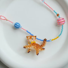 Beaded necklace with a cat pendant on a white background