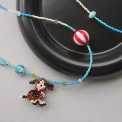 Beaded necklace with a beagle dog charm on a black and white background