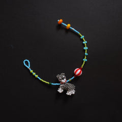 Colorful beaded bracelet with a small Schnauzer dog charm on a black background