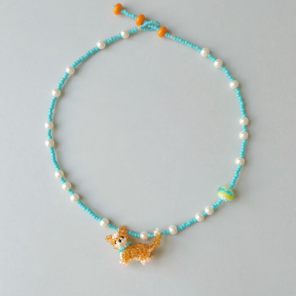 Necklace with a Corgi dog charm on a light gray background