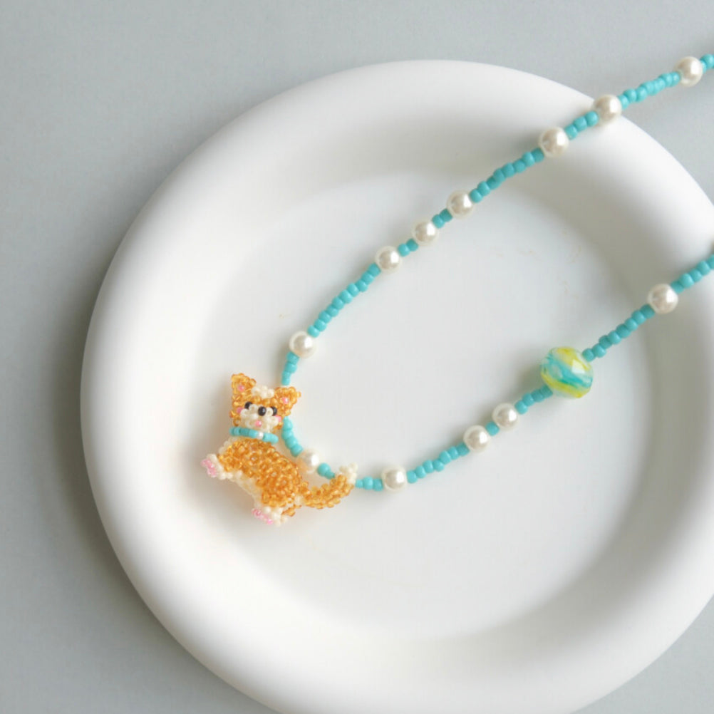 Necklace with a Corgi Dog pendant on a white plate