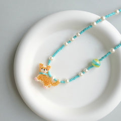 Necklace with a Corgi Dog pendant on a white plate