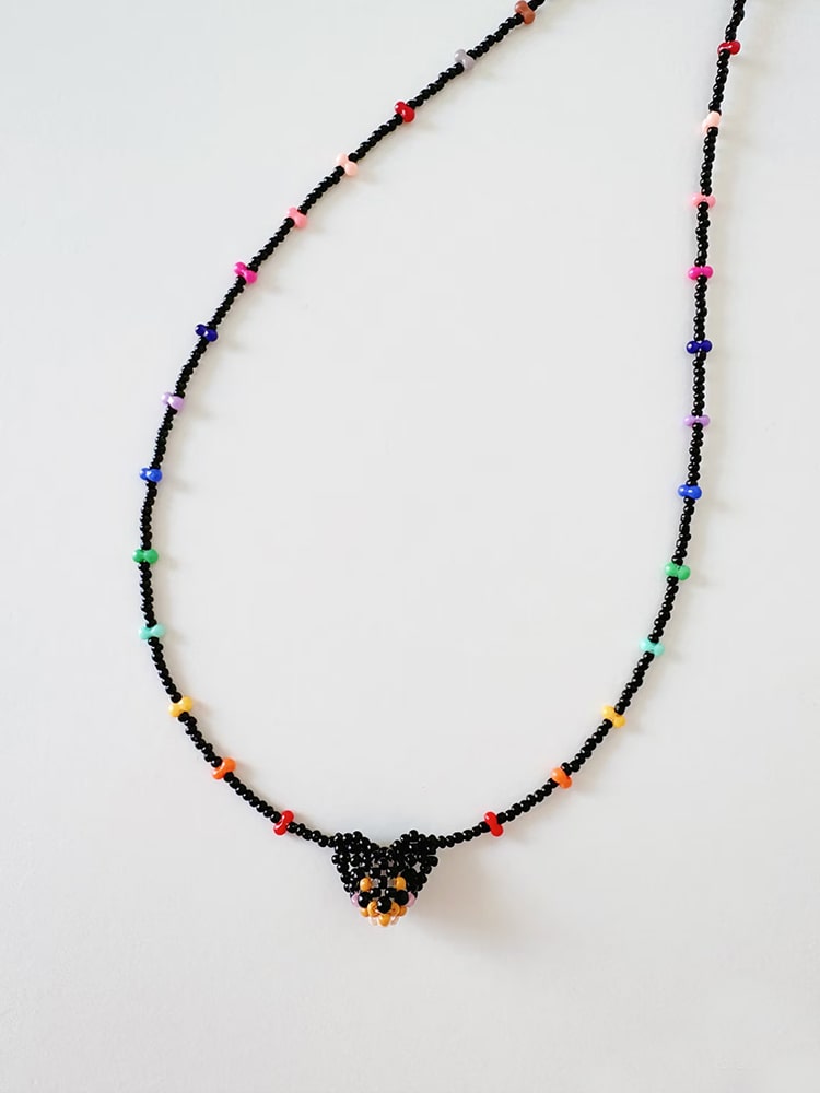 Beaded necklace with a chihuahua  dog pendant on a white background