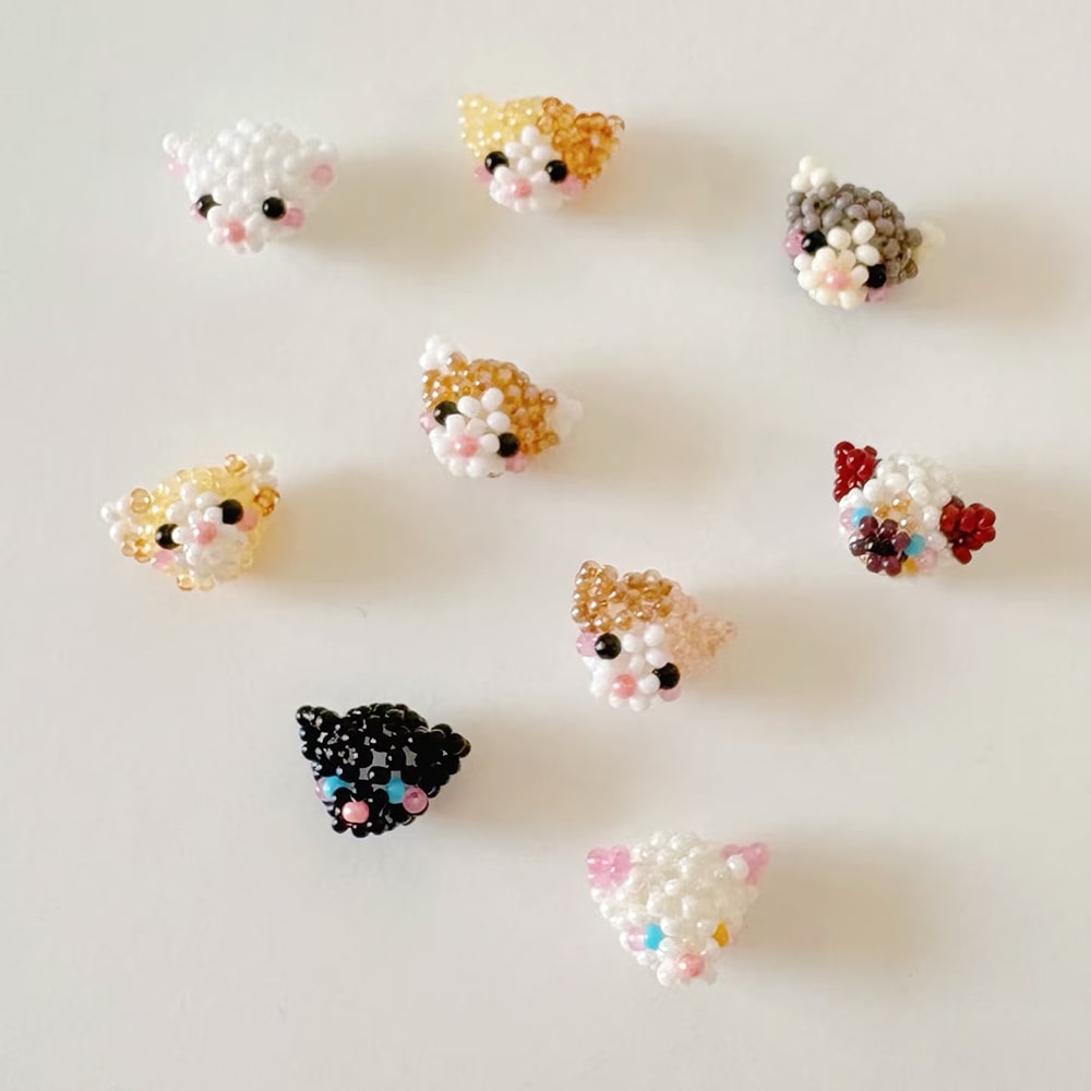Small beaded cats with bead details on a light background