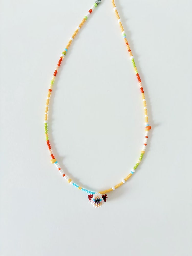 Colorful beaded necklace with a siamese cat on a light gray background