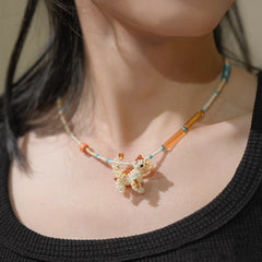 A person wear a beaded Calico cat necklace