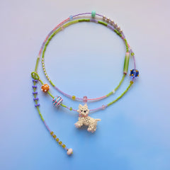 Colorful beaded necklace with a handmade Westie dog charm on a gradient background