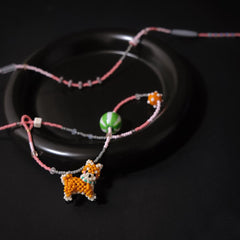 Neckalce with a Shiba Inu dog charm on a dark background