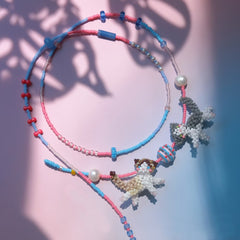 Colorful beaded necklaces with couple cats charms on a gradient background