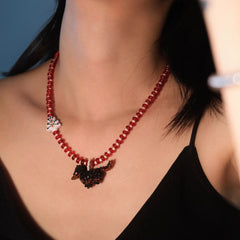 Handmade christmas beaded necklace with a Dachshund dog  pendant worn by a person against a blue background - verhalo jewelry