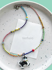 Colorful beaded necklace with a Husky dog pendant on a speckled plate, featuring the brand 'Verhalo'.