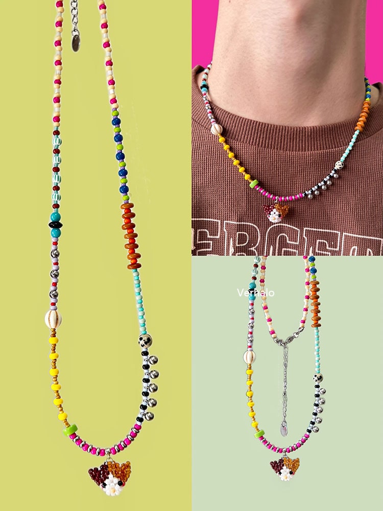 Colorful beaded necklace with a Calico cat charm on a green background - Verhalo handmade jewelry