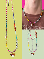 Colorful beaded necklace with a Calico cat charm on a green background - Verhalo handmade jewelry