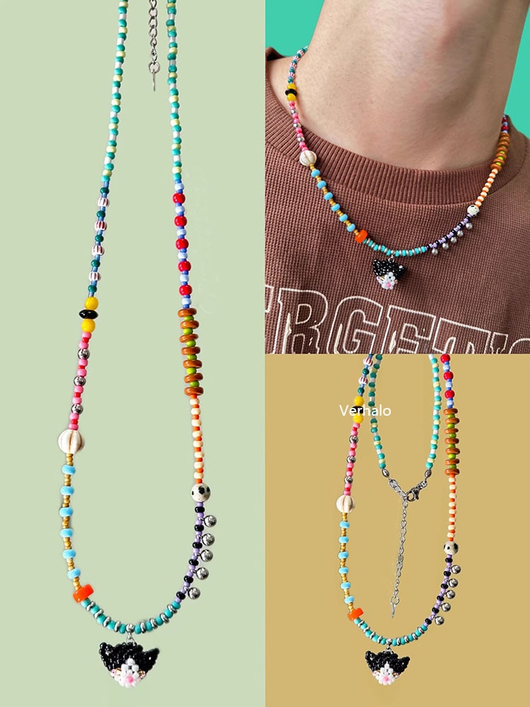 Colorful beaded necklace with a black cat charm on a green background - Verhalo handmade jewelry