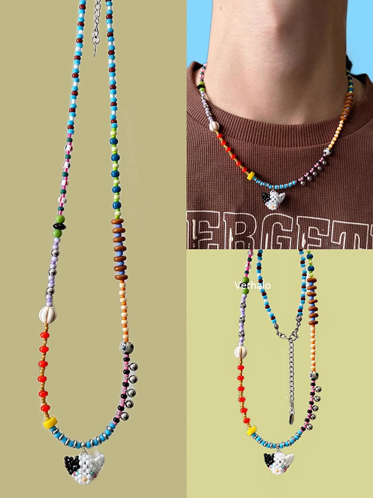 Colorful beaded necklaces with a black and white cat charm on a plain background - Verhalo handmade jewelry