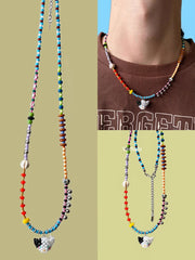 Colorful beaded necklaces with a black and white cat charm on a plain background - Verhalo handmade jewelry