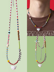 Colorful beaded necklaces with white cat charm on a green background - Verhalo handmade jewelry